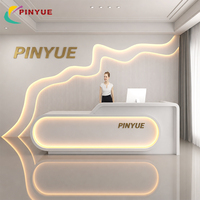 Comptoir de réception blanc incurvé avec éclairage LED sur le bord, panneau mural ondulé et comptoir avant moderne pour bureau, hall d'hôtel, design personnalisé