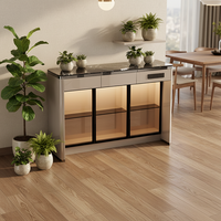 Meuble bar moderne de luxe en MDF laqué brillant avec plateau en pierre frittée, cadre en aluminium, portes vitrées et éclairage LED pour rangement dans le salon