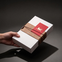Boîte cadeau blanche minimaliste haut de gamme en carton rigide avec ruban en tissu et étiquette dorée pour cadeaux d'entreprise et festivals, personnalisation de marque