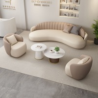 Chaise de canapé en cuir incurvé de luxe léger avec table à thé pour le salon de beauté dans le hall de l'hôtel