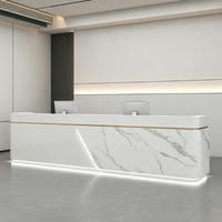 Bureau d'accueil moderne sur mesure effet marbre avec accents métalliques et éclairage LED pour bureau d'entreprise ou hôtel