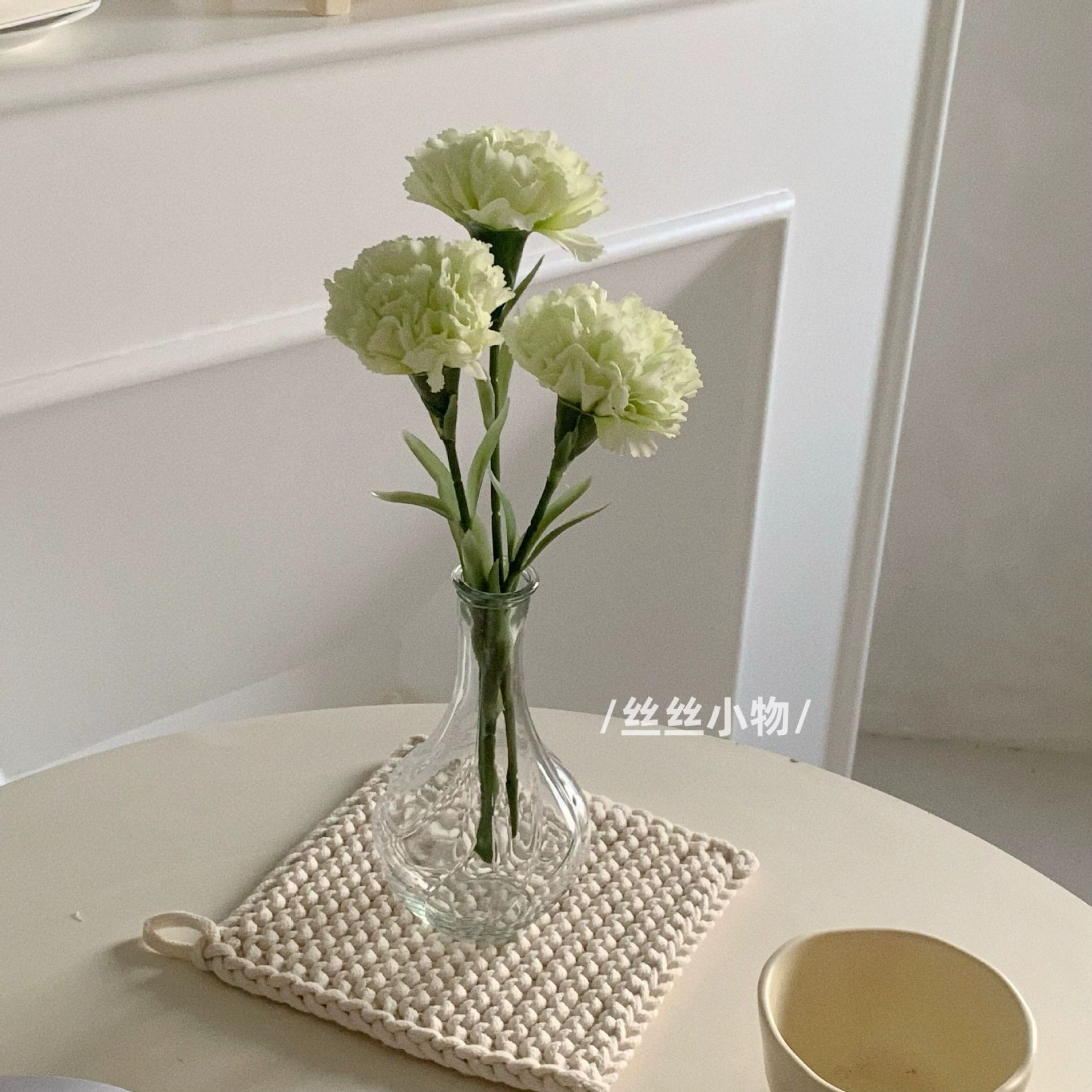 Un vase en verre vert clair avec trois tiges