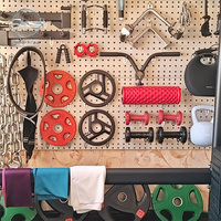 Panneau mural perforé pour rangement et présentation d'équipements de fitness à domicile : bandes de résistance et haltères