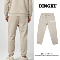 Pantalon de jogging fuselé beige pour homme avec revers côtelés, poche plaquée pentagonale, taille élastique avec cordon de serrage, poche oblique et fausse braguette, style décontracté