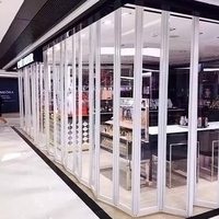Porte pliante moderne en alliage d'aluminium avec cadre incurvé en cristal, cloison transparente sur mesure pour les intérieurs de centres commerciaux et de magasins