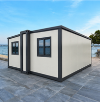 Maison conteneur pliable extensible Off White avec structure gris foncé et fenêtres à double vitrage pour le glamping en bord de lac