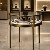 Vitrine de présentation de bijoux en laiton rond avec plateau rotatif intérieur, vitrine en verre trempé, quatre pieds, comptoir de bijouterie