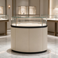 Vitrine à bijoux circulaire de luxe avec niches murales LED, sol en marbre, accents dorés, présentoir en verre, solution d'aménagement de boutique