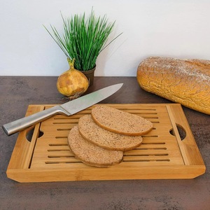 Tabla de cortar ecológica de bambú con ranuras y bandeja recolectora de migas, para uso en la cocina. - Product Image 2
