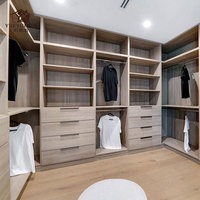 Grande dressing moderne ouverte avec finition en bois naturel et tiroirs à fermeture amortie