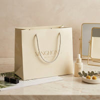 Sac en papier ivoire élégant avec logo personnalisé en or à chaud, idéal pour les boutiques de cosmétiques, emballage cadeau, soins de la peau