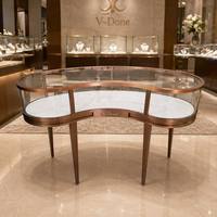 Comptoir de présentation de bijoux en métal rose doré de luxe, forme en C, avec dessus en verre trempé transparent, revêtement en marbre, logo de marque personnalisé