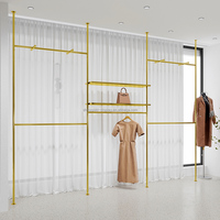 Présentoir pour vêtements de la boutique personnalisée Présentoir mural pour vêtements pour magasins de vêtements Présentoir pour vêtements doré pour magasin de vêtements
