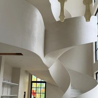 Escalier de villa courbé de style crème, artistique et durable, avec des contours doux et tourbillonnants, construction métallique moderne pour intérieur, garde-corps en fer forgé