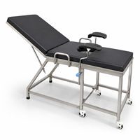 Table d'examen gynécologique en acier inoxydable pour centre médical avec supports de jambes rembourrés et structure stable