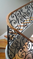 Escalier courbé traditionnel intemporel avec balustrades ornées pour rénovation historique