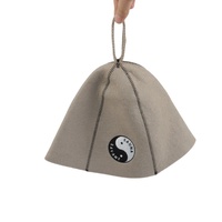 Un chapeau de sauna en pure laine beige qui équilibre la vapeur avec un emblème Yin Yang qui profite de chaque côté de la chaleur
