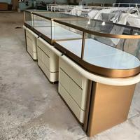 Comptoir de présentation de bijoux incurvé en acier inoxydable or rose de luxe, vitrine minimaliste pour boutique avec éclairage LED flottant