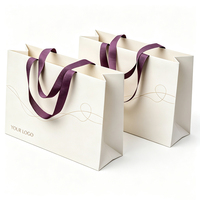 Sac cadeau en papier kraft noir écologique et durable, bordure dorée, poignées en ruban gaufré, emballage artisanal personnalisable, vente en gros