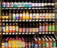 Système d'étagères à gravité avec revêtement plastique OFL, capacité et dimensions personnalisables pour l'organisation des boissons coulissantes en supermarché