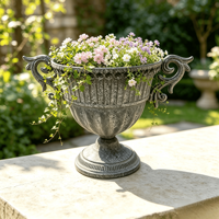 Pot de fleurs vintage en fer de style manoir français avec doubles poignées, rainures verticales et base surélevée pour aménagement paysager et plantation de verdure