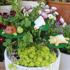 Animali dei cartoni animati stanno <span class=keywords><strong>pigramente</strong></span> godendosi il piacere dei fiori e delle foglie di loto. Decorazione a forma di tartaruga magnetica da inserire nel bonsai - Product Image 1