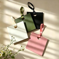Sacs cadeaux en carton blanc de luxe personnalisés avec poignées en corde de satin et trou rond pour l'emballage de vêtements et de parfums haut de gamme