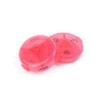 Boîte à pilules ronde en plastique rose avec des icônes soleil et lune pour le rangement des médicaments