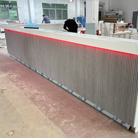 Comptoir de bar moderne en forme de L avec dessus en Corian blanc et façade gris foncé, éclairage LED RGB sous le comptoir, personnalisable pour restaurant/hôtel/club