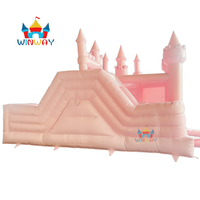 Château gonflable rose sur le thème des princesses avec piscine à balles, aire de jeux extérieure pour enfants.