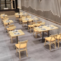 Ensemble de banquettes en bois clair avec chaises rembourrées orange beige et tables à piétement noir pour restaurant moderne