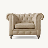 Fauteuil Chesterfield classique capitonné en lin crème, fauteuil club avec accoudoirs roulés et pieds à roulettes, design sud-ouest pour villa