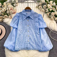 Chemise rétro de style court avec empiècements en dentelle et manches lanternes en maille légère et fluide, un haut féminin sophistiqué et jeune.