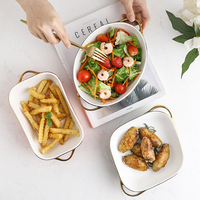Vente en gros Nouveau produit Assiette ovale en céramique pour la cuisson du fromage et du riz avec double oreille dorée