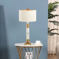 Lampe de table colonne moderne de luxe en laiton doré avec base en pierre texturée marbre et abat-jour en tissu pour la décoration de projets hôteliers et de villas