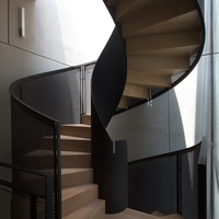 Escalier hélicoïdal design pour intérieur de luxe avec effet de marches flottantes et balustrade en verre sur mesure