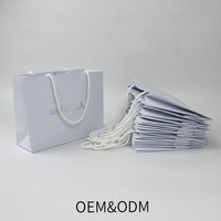 Sacs en papier blancs de luxe pour vêtements de marque, avec poignée, personnalisés avec logo imprimé, pour la promotion, la vente au détail et les cadeaux