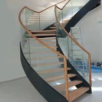 Escalier courbé avec garde-corps en panneaux de verre minimalistes et lignes fluides pour les halls commerciaux haut de gamme et les immeubles de bureaux