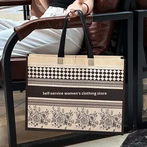 กระเป๋าถือแฟชั่นแบบไม่ถักทอ พิมพ์โลโก้ตามสั่ง สำหรับร้านเสื้อผ้าระดับไฮเอนด์ ถุงช้อปปิ้งเคลือบลามิเนต บรรจุภัณฑ์เสื้อผ้าสตรี ผลิตในจีน - Product Image 1