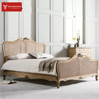 Lit double de luxe de style américain en bois massif, finition bois ciré blanc, avec tête de lit rembourrée en osier et motifs sculptés à la française