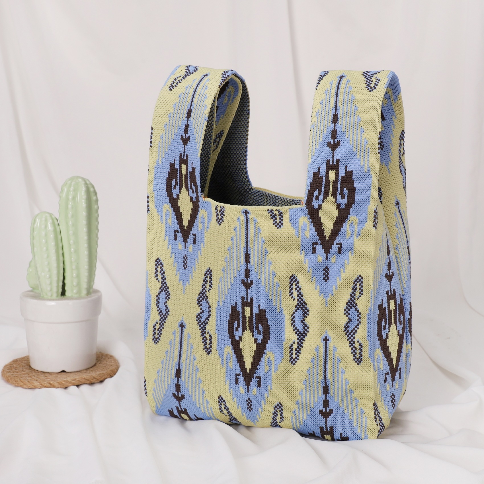 Petit sac bleu clair et jaune en forme de flèche à motif losanges