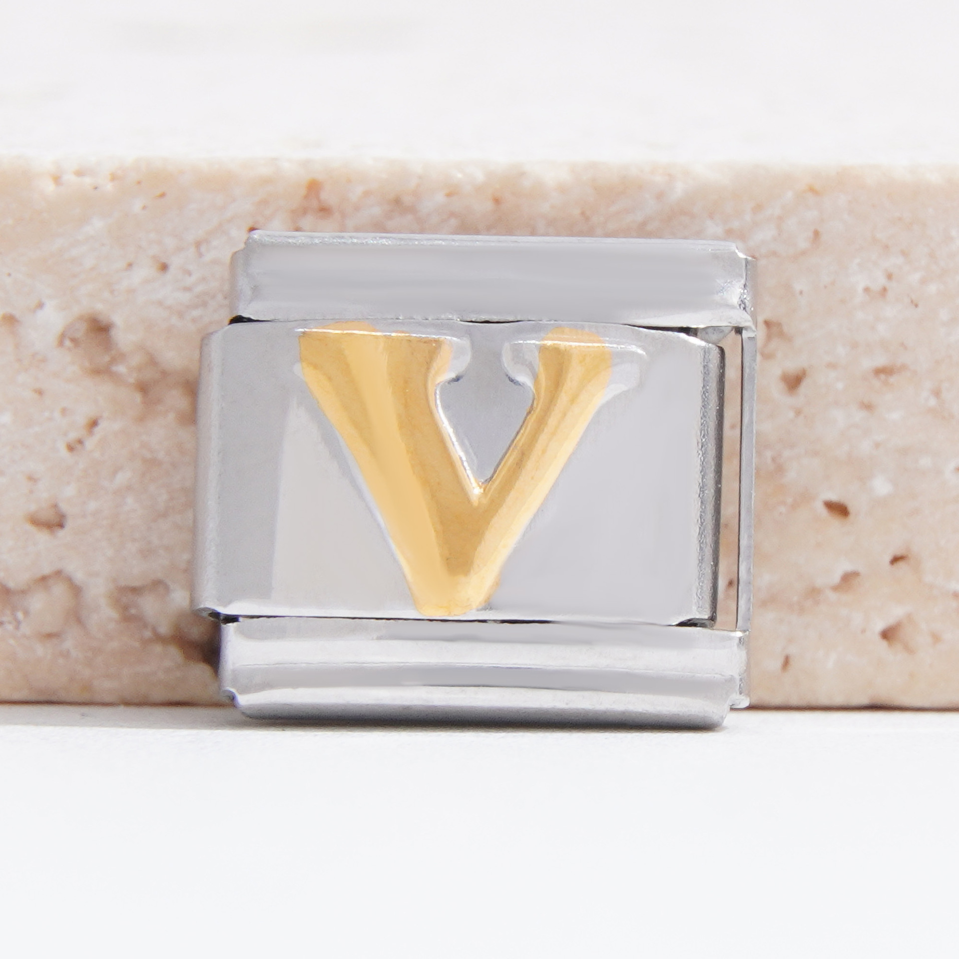 Base plateada con V dorada.