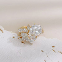 Anelli di fidanzamento da donna in oro giallo 18 carati con diamante coltivato in laboratorio, stile lusso leggero, con pietra centrale a goccia e cluster di diamanti.