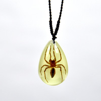 Collier en ambre avec scorpion réel en résine luminescente et graphismes brodés
