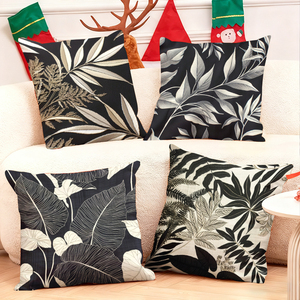 Élégantes coussinets décoratifs botaniques noirs et blancs pour une ambiance chaleureuse dans le salon, avec des chaussettes de Noël festives et des décorations en forme de bois de cerf. - Product Image 1