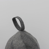 Un chapeau de sauna en pure laine de charbon de bois qui dissimule la chaleur et laisse apparaître seulement une petite silhouette dansante sur une étiquette blanche