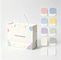 Sac cadeau en papier crème personnalisé avec imprimé géométrique coloré, poignée en corde de coton, logo de marque personnalisé pour l'emballage de vente au détail en boutique