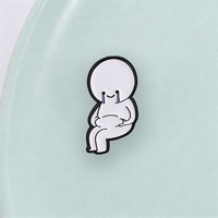 Broche en métal contrastante avec figurine doodle simple assise, visage souriant et larmes bleues, style art meme pour la culture des memes