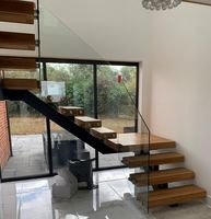 Escalier flottant moderne en acier au carbone à poutre unique avec marches en bois de hêtre pour usage intérieur