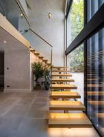 Escalier flottant incurvé moderne pour villa avec garde-corps en verre et éclairage LED